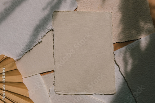 Handmade cotton rag deckle edge paper cards on beige background with soft leaves shadows.  Branding, portfolio, graphic design template. Wedding stationery.  photo