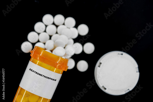 Dextromethorphan Rx medical pills in plactic Bottle with tablets. Pills spilling out from yellow container. photo