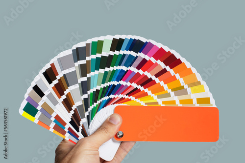 Fotografija Hand holding a color palette guide, metallic color samples