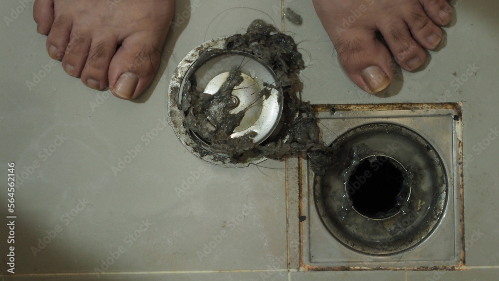 Drain cleaning. Clogged and dirty sewer pipes floor drain. Full of hair