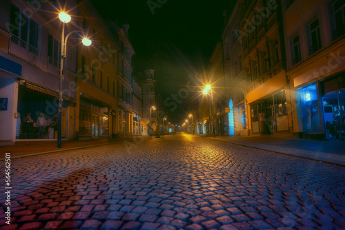 street covered with paving stones in an old European city on a foggy night