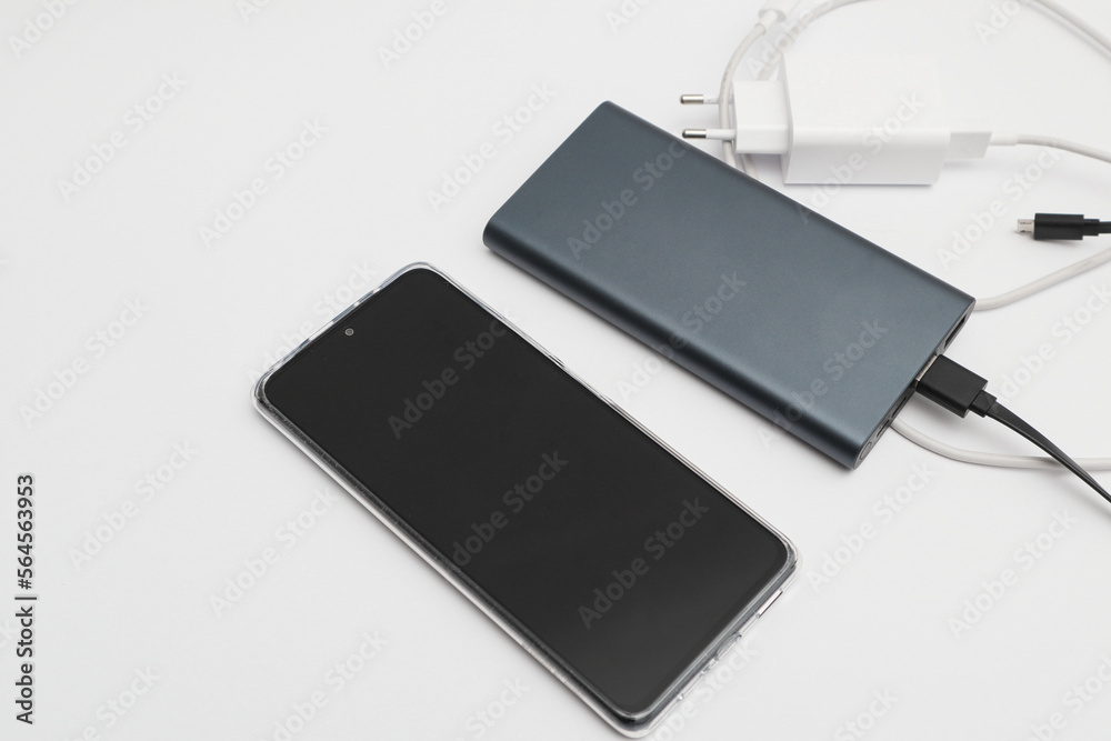 Power bank and smartphone on white background. Modern technology concept. Power bank and smartphone on white background. Modern technology concept.