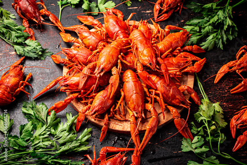 Boiled crayfish on a wooden cutting board with parsley. 