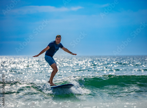 Man learns surf on the surfboard getting used to stand