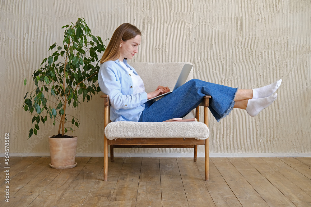 Young woman sitting in chair with laptop Young woman sitting in chair with laptop