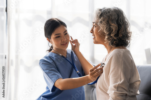 Wallpaper Mural Stethoscope exam. Attractive cheerful asian female doctor listening to the elderly while using stethoscope Torontodigital.ca