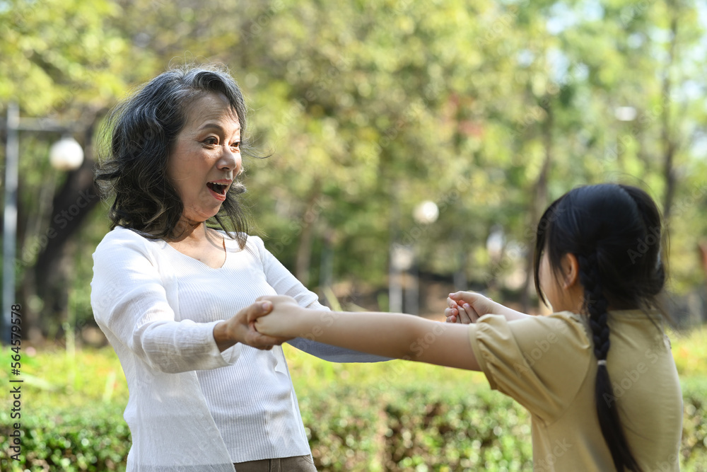 Joyful little asian girl playing games with grandmother, spending leisure weekend time together in the public park. Joyful little asian girl playing games with grandmother, spending leisure weekend time together in the public park.