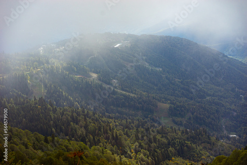 Mountain range with visible silhouettes through the morning colorful fog. © STOCKIMAGE