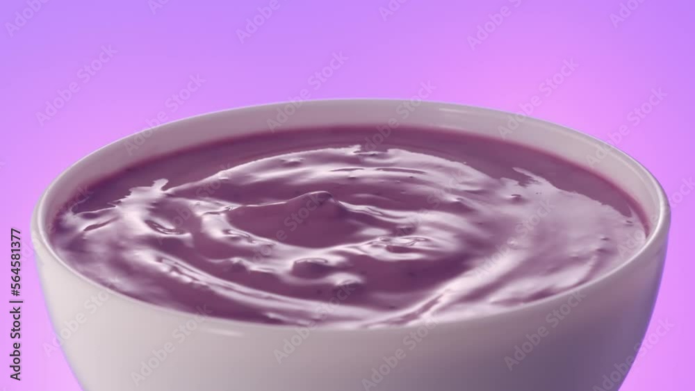 Berry yogurt in a white bowl rotates on a colored background. blueberry cream closeup Berry yogurt in a white bowl rotates on a colored background. blueberry cream closeup