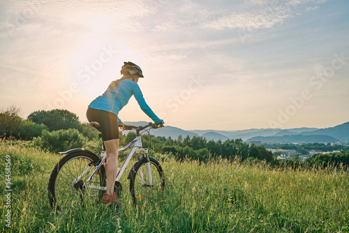 Foto Cyclist Woman riding bike in helmets go in sports outdoors on sunny day a mountain in the forest