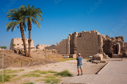 Tourist photographing the ruins of the Karnak temple outside Luxor, Egypt