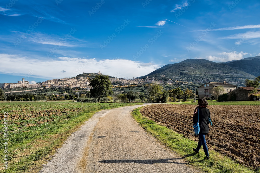 assisi, italien - frau auf einem feldweg nach assisi