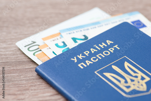 Ukrainian biometric passport with euro banknotes in it, close up. Work and travelling abroad, european currency concept