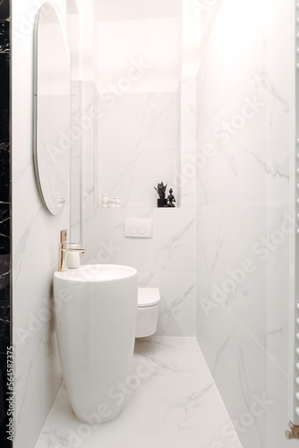 Details of fancy bathroom with modern appliances and LED mirror, freestanding sink with white marble background