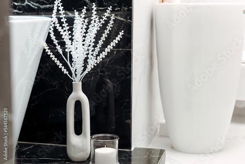 Details of fancy bathroom with modern appliances and LED fixtures, freestanding tub with black and white marble