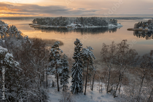Soukka, Finland - 09.12.22: Top view of the snow-covered Soukka Islands in Espoo. Sunset on a winter day. There is ice on the water in places. Winter landscape. Scandinavia.