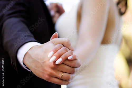 bride and groom hold hands. Close-up of newlyweds hands
