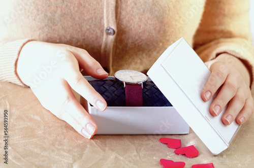 Close up of hands holding a gift box with a watch for Valentine's Day, Mother's Day, Father's Day and for your him/her.