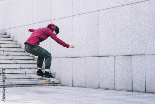 Asian woman skateboarder skateboarding in modern city