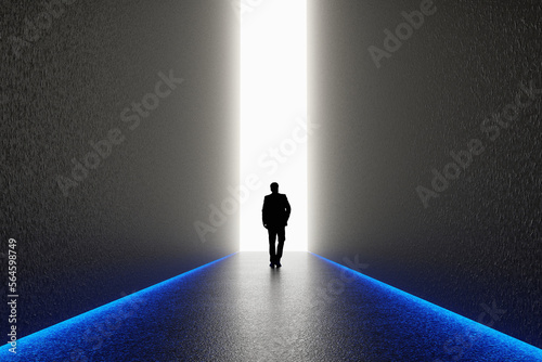 The silhouette of a man walking towards a bright light in the opened huge wall. A light in the end of a tunnel. The concept of success, freedom of choice, open mind, meditation.