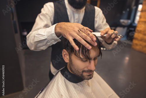 Male hairdresser working with the client in the babershop