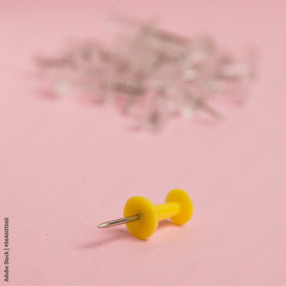 Yellow push pin macro on paper pink background with copy space Yellow push pin macro on paper pink background with copy space