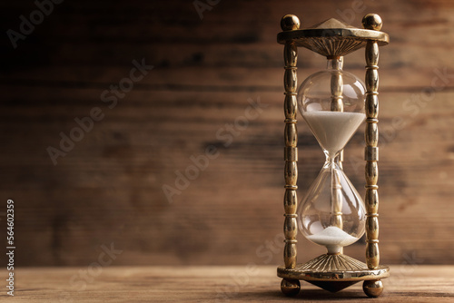 Hourglass on the wooden table with a wooden background