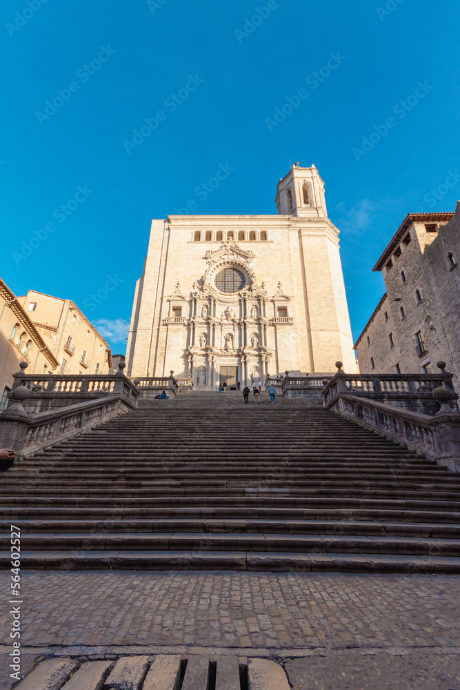 Catedral de la ciudad de gerona con todos los largos escalones para llegar a su puerta bajo un cielo azul soleado.