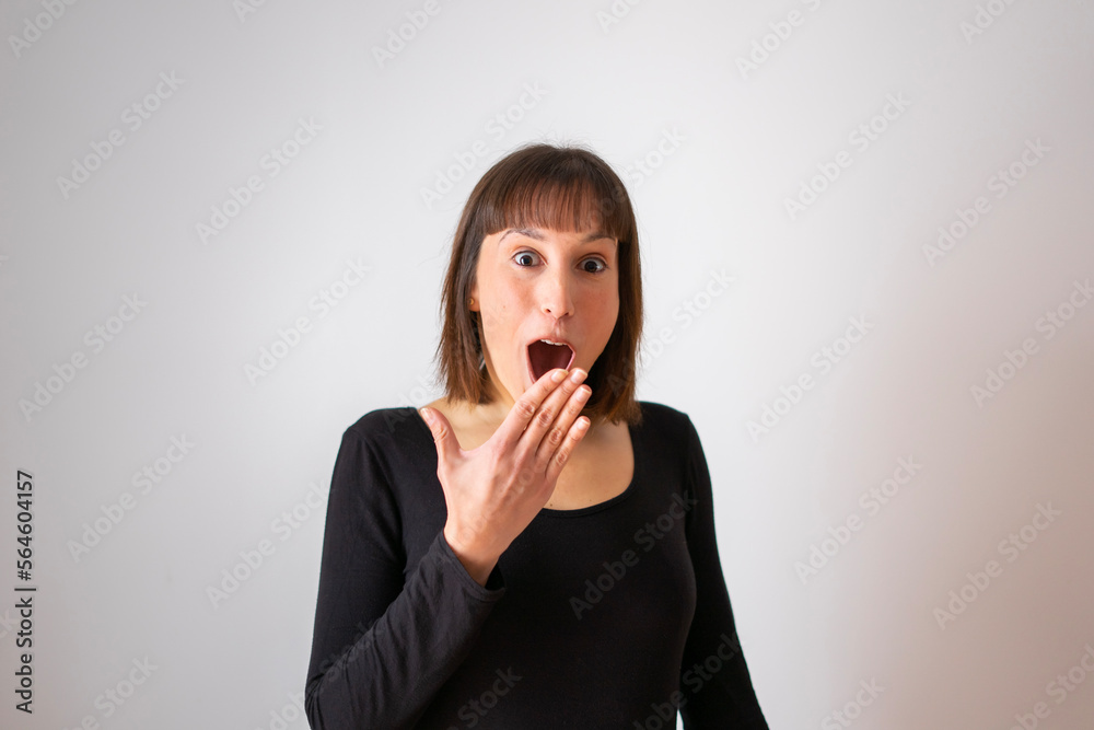 Portrait of a girl on white background. Brown short hair girl. Happy and surprised girl, with a hand in front of her mouth. Portrait of a girl on white background. Brown short hair girl. Happy and surprised girl, with a hand in front of her mouth.