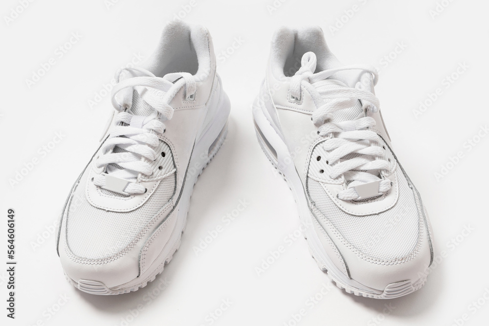 White leather trainers with a shadow on white background