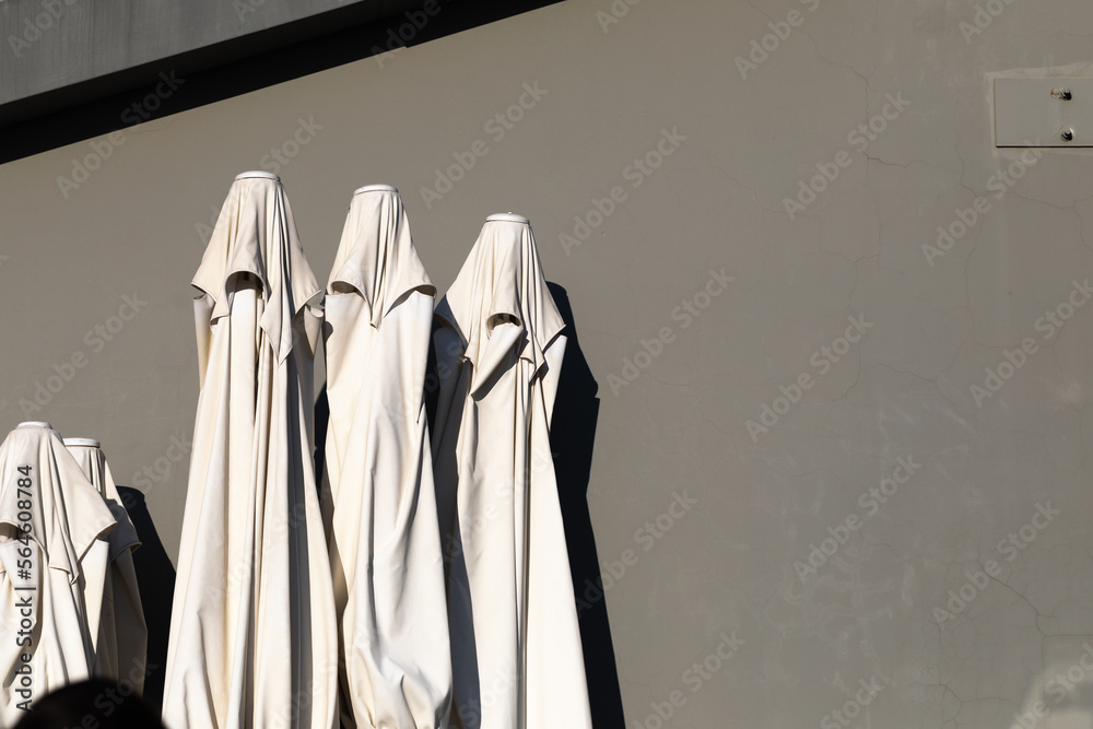 Fototapeta premium Closed umbrellas against the grey wall.