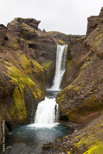 Waterfall in Iceland. Vertical photo of water stream flowing through cliffs.
