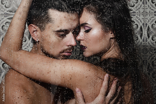 Beautiful and sensual couple captured through wet glass