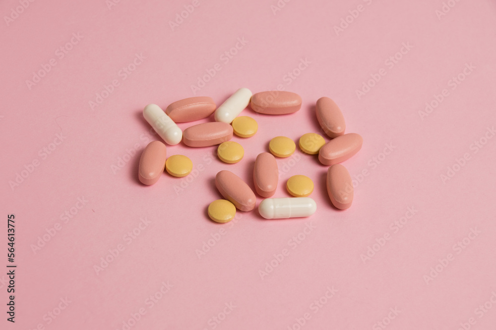 Flat lay, colorful pills and medical capsules on pink background Flat lay, colorful pills and medical capsules on pink background