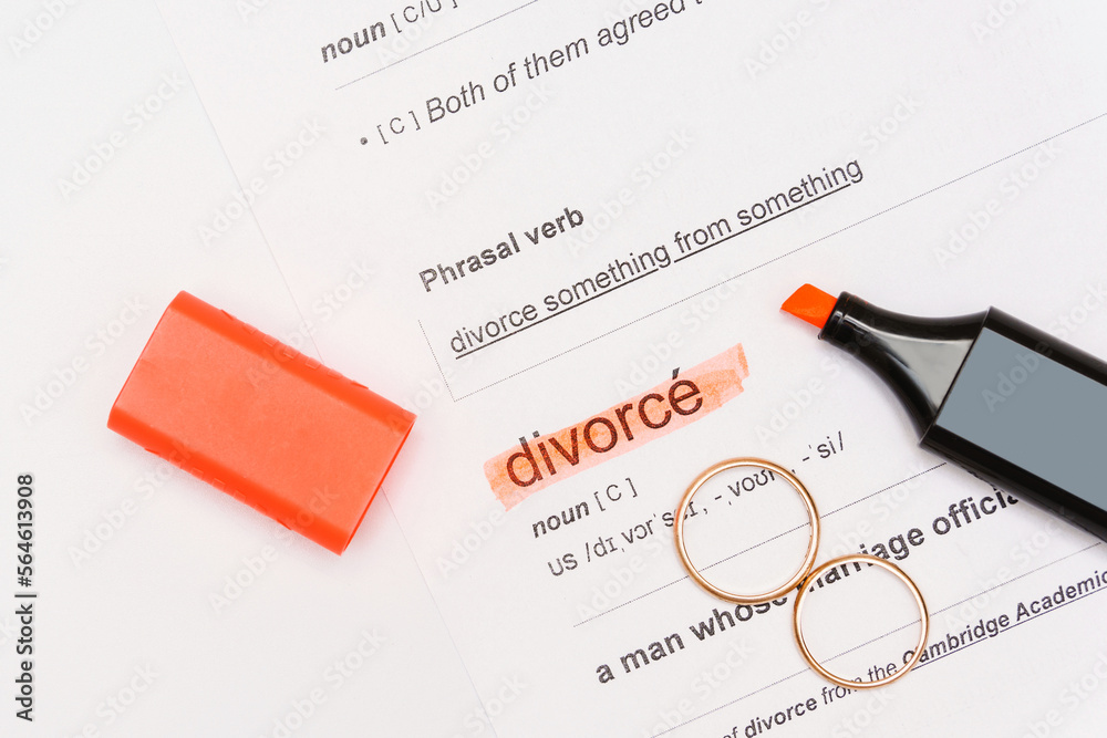 Fototapeta premium Two golden wedding rings and highlighter pen with marked divorce word