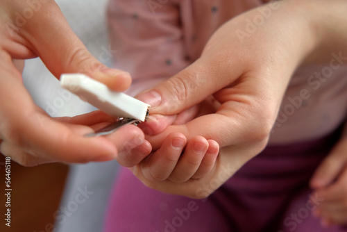 Mother use Nail Trimmer with baby hand. Mom cutting tiny fingernails. Baby care concept. How to successfully clip your baby s nails. Closeup. Newborn hygiene. Clipping Child s Nails. Front view.