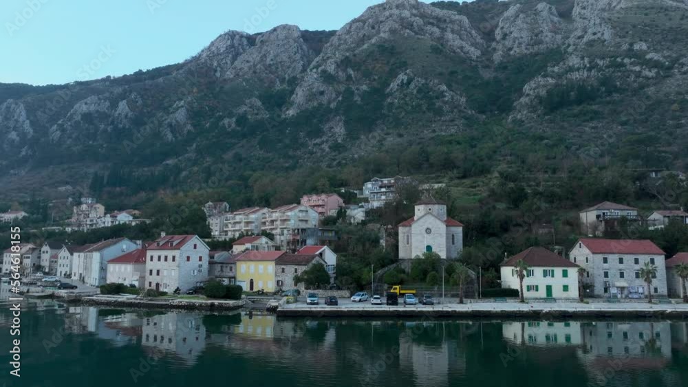 Coast road in kotor bay. Aerial view. Mountains in background. Car drive in the road. Fly over the bay Coast road in kotor bay. Aerial view. Mountains in background. Car drive in the road. Fly over the bay