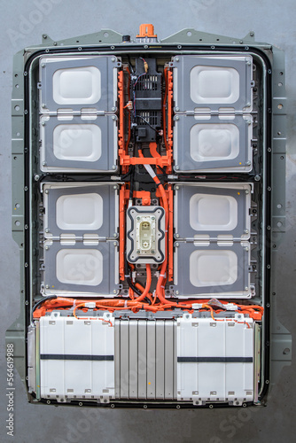 Top view of an electric vehicle battery with the cover removed, revealing the internal components such as cells, heating system, wiring, switching box, service plug, power buses and connectors. 