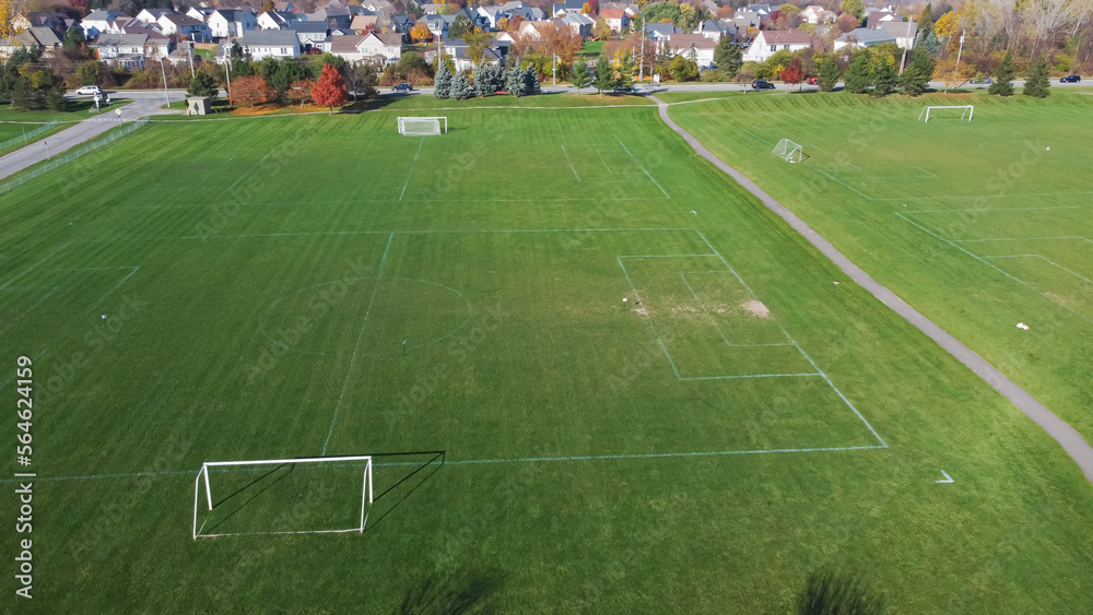 Obraz premium Aerial view empty soccer field in community park near residential neighborhood with colorful fall foliage in Rochester, New York, USA