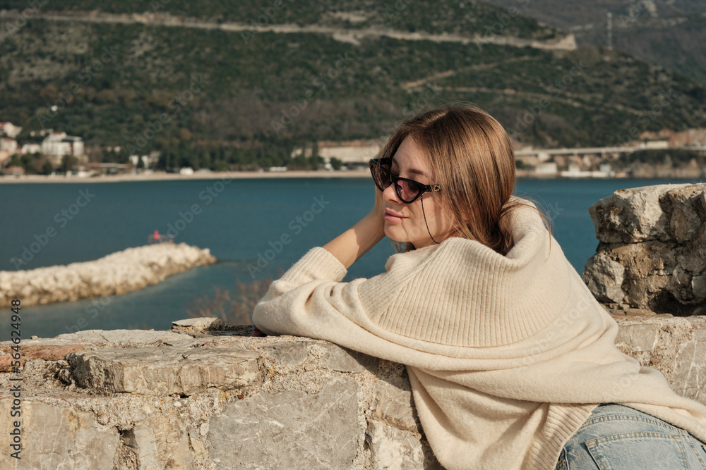 The girl leaned her hands against a stone wall, closed her eyes and dreams The girl leaned her hands against a stone wall, closed her eyes and dreams