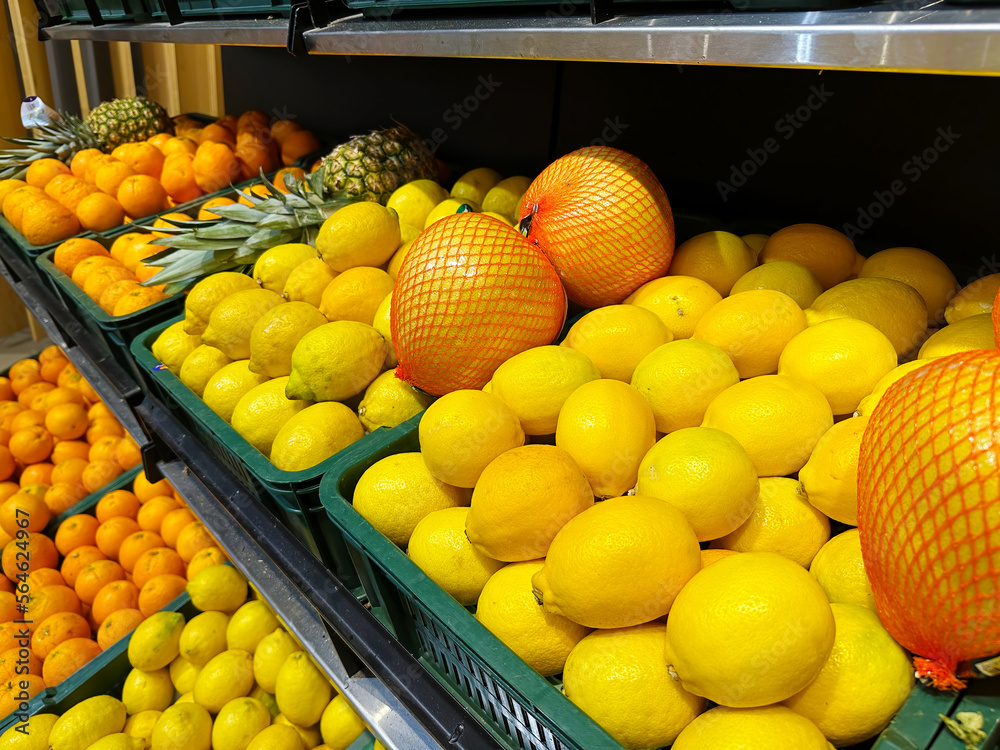 Fruits counter shelf in the city supermarket with ripe lemons and oranges. Shop and bazaar backgrounds