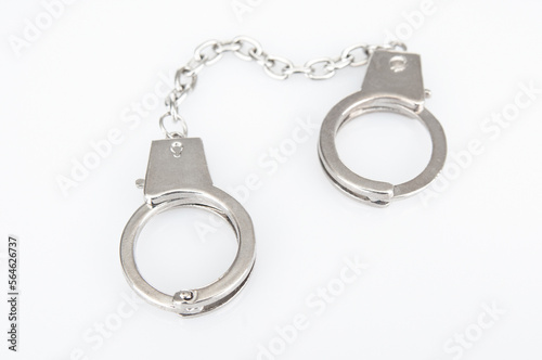 Metal handcuffs on a white background © unclepodger