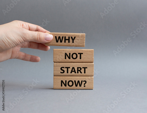 Why not start now symbol. Concept words Why not start now on wooden blocks. Beautiful grey background. Businessman hand. Business and Why not start now concept. Copy space.
