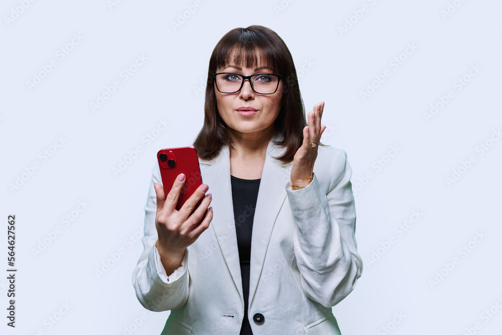 Portrait of serious middle aged business woman with phone on white background Portrait of serious middle aged business woman with phone on white background