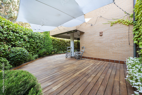 Papier peint Terrace of a ground floor house with hedges and ornamental plants, slatted acaci