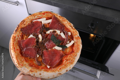 Frozen pizza with beef in the kitchen