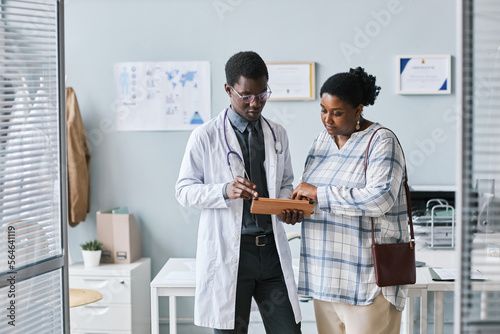 Young African American doctor consulting female patient in clinic