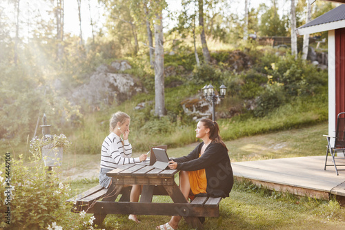 Female friends sitting on picnic bench photo