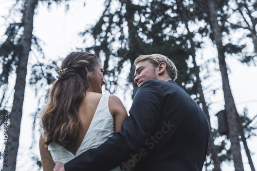 Back view of a Bride and Groom in a forest during winter. High quality photo