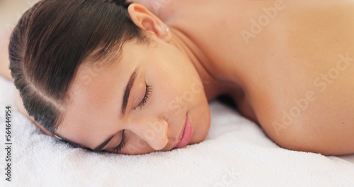 Spa  wellness and woman  calm and happy  peaceful after massage  massage therapy for body health and zen. Young person satisfied  lying down and carefree with peace and serene  stress relief.